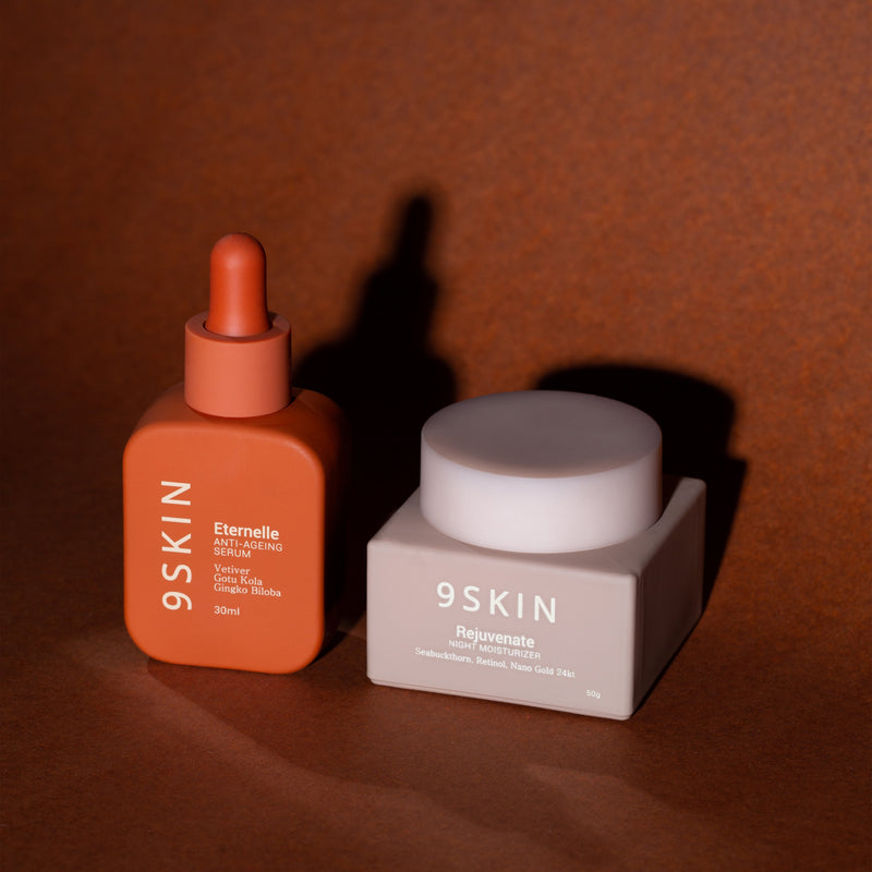 Orange serum bottle and gray cream jar with '9SKIN' branding on a brown textured background