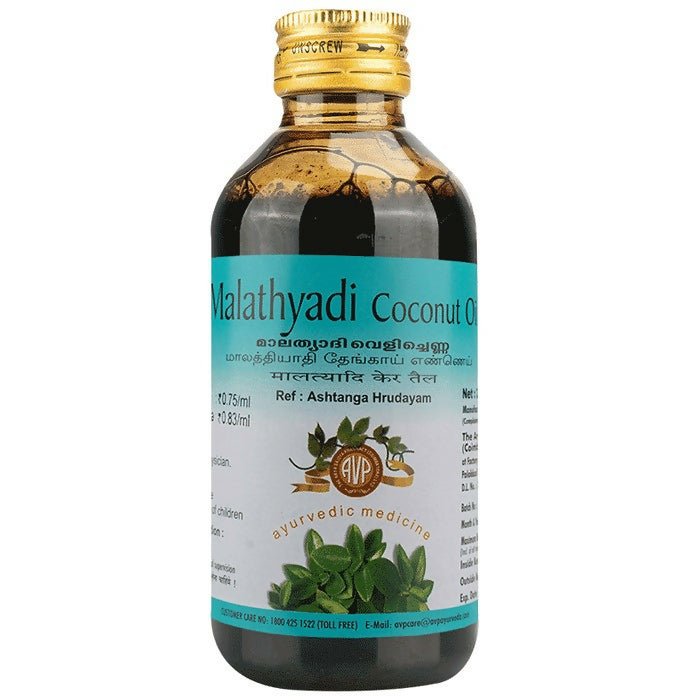 Bottle of Malathyadi Coconut Oil with a gold cap on a white background