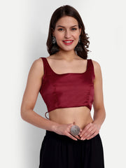 Woman wearing a maroon top and black skirt against a white background