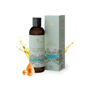 Bottle and box of cold pressed castor oil with decorative elements on a white background