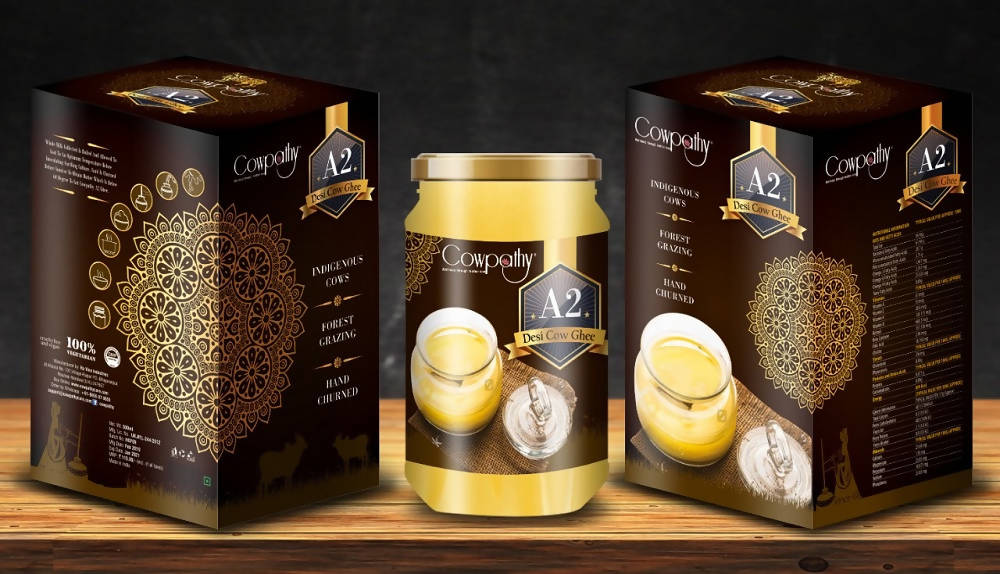 Two jars of Coppenhåg A2 yogurt with their packaging on a wooden surface.