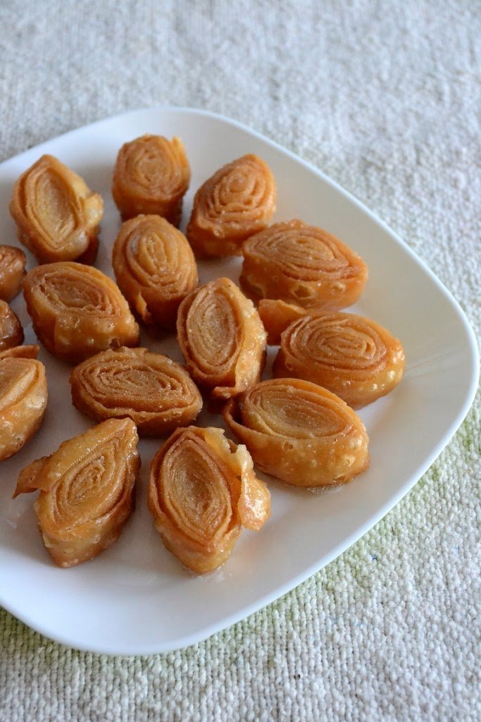 Rolled dough snacks on a white plate with a textured background