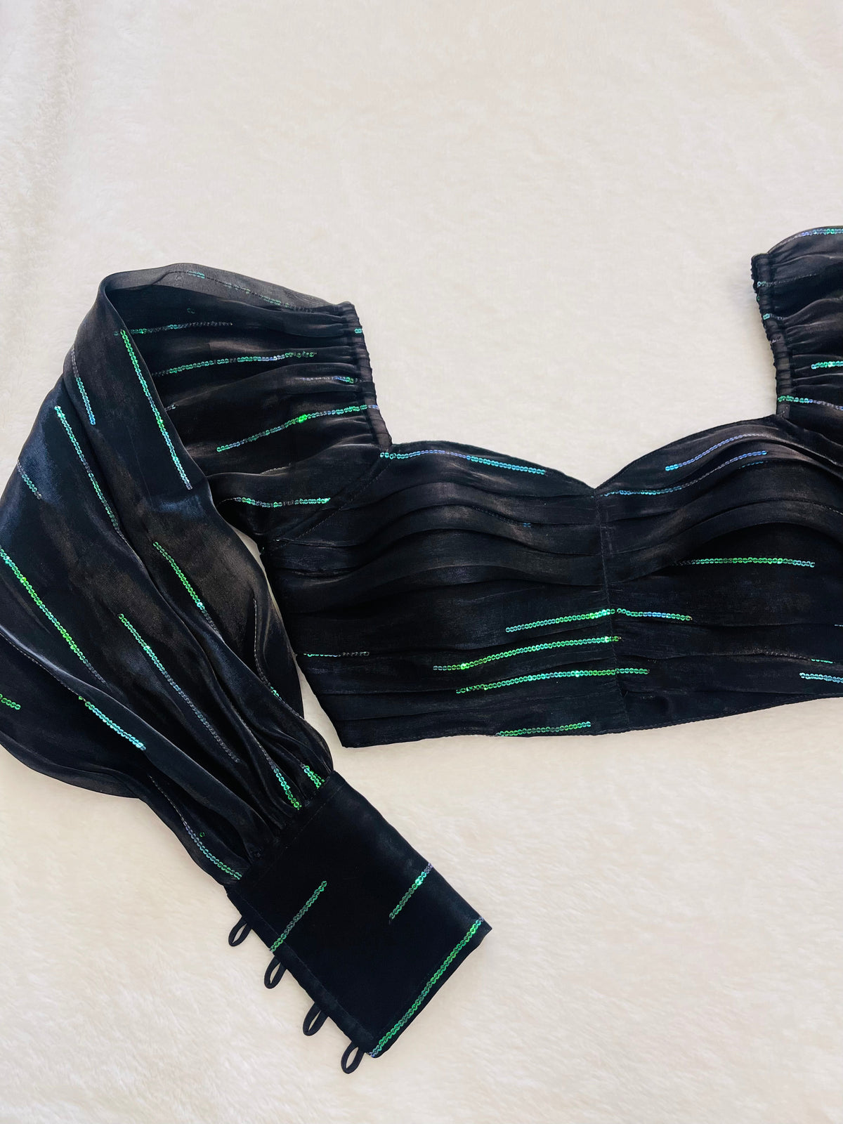 Black strapless top with green accents on a white background