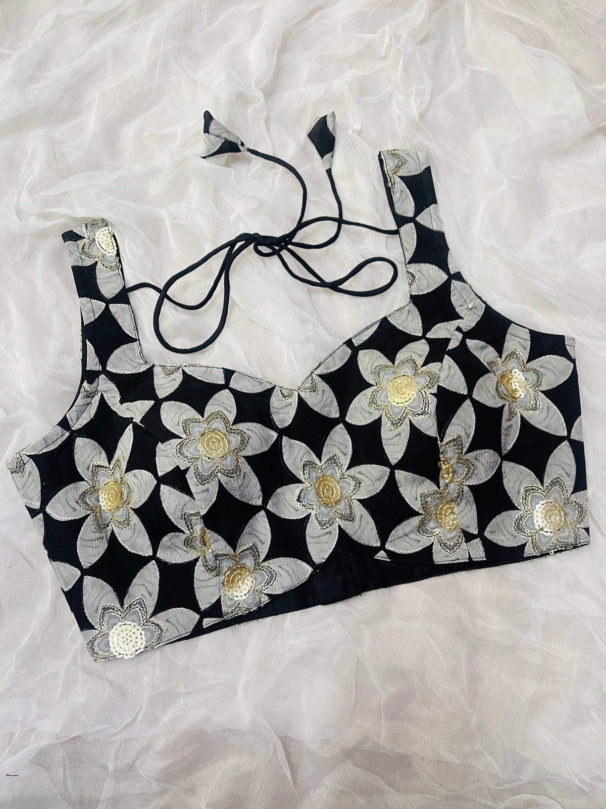 Black crop top with white floral patterns on a white background