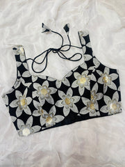 Black crop top with white floral patterns on a white background