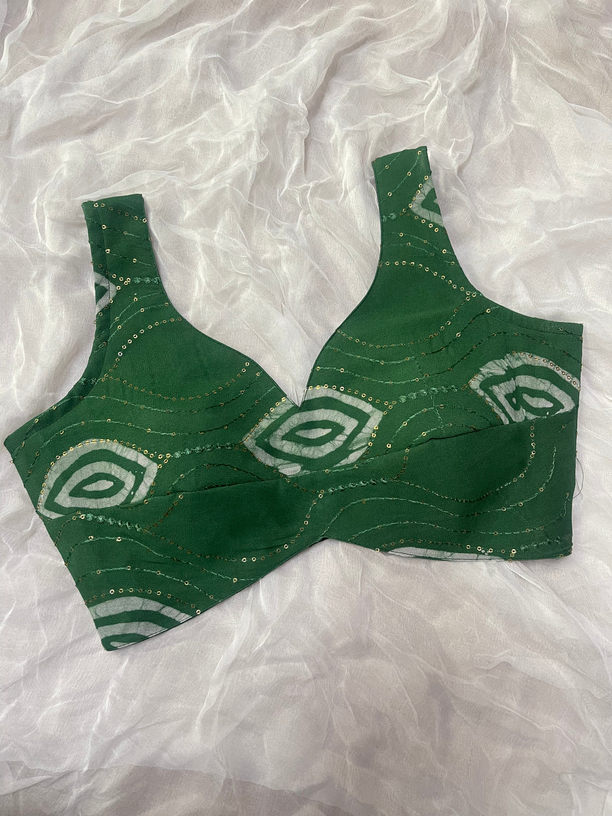 Green patterned bra on a white fabric background