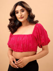 Woman wearing a pink blouse with short sleeves on a beige background