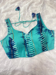 Teal bikini top with abstract pattern on a white fabric background