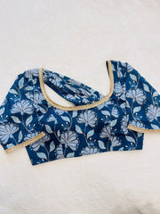 Blue floral blouse with beige trim on a white background