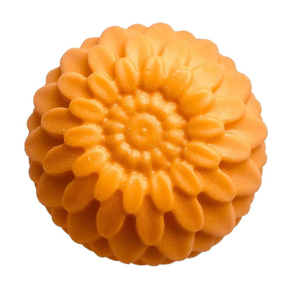 A round orange bar of soap with a floral pattern on it.