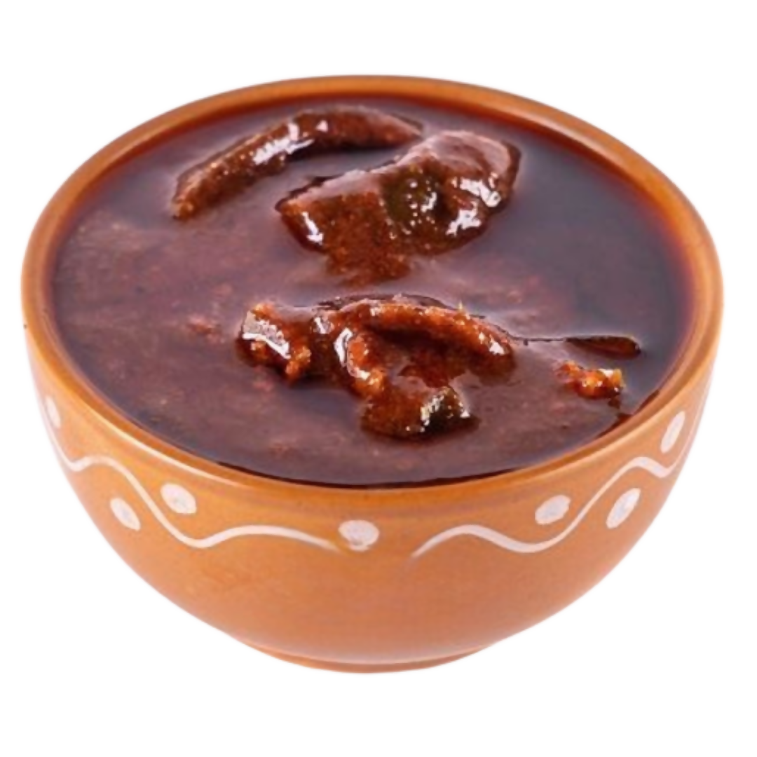 Ceramic bowl with a dark brown sauce and pieces of food on a white background