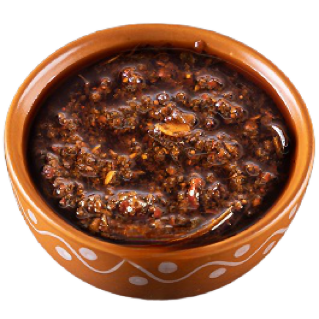 Brown sauce in a decorative terracotta bowl on a white background
