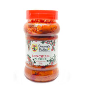 Jar of red chilli pickle with a visible label on a white background