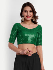 Woman wearing a green sequined top against a white background