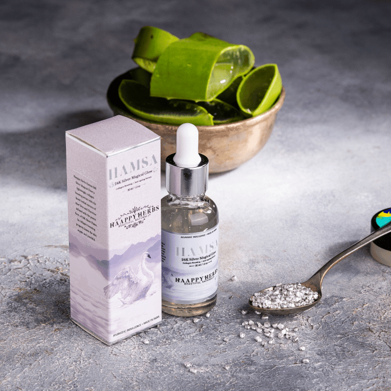 Hamsa skincare product with aloe vera leaves on a gray surface