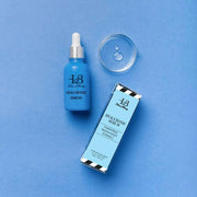 Hyaluronic serum bottle and packaging on a blue background