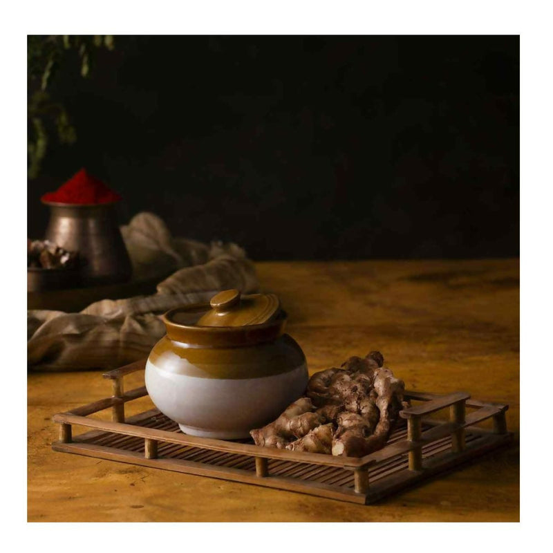 Ceramic jar with a lid on a wooden tray with a dark background