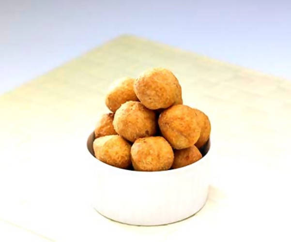 Bowl of fried dough balls on a white background
