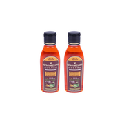 Two bottles of Kesavardhan Plus hair oil on a white background