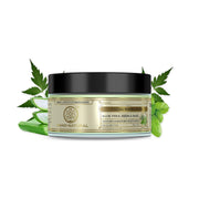Facial masque jar with aloe vera, neem, and basil leaves on a white background