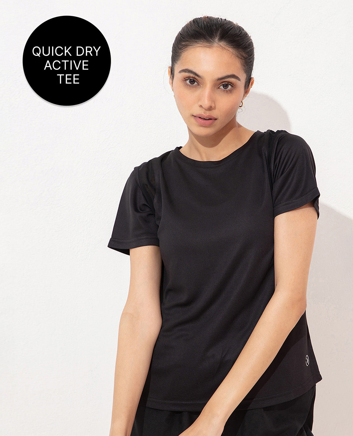 Woman wearing a black quick dry active tee on a white background