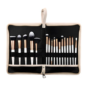 Set of makeup brushes in a black and beige case on a white background