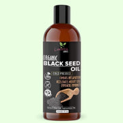 Bottle of organic black seed oil on a light green background