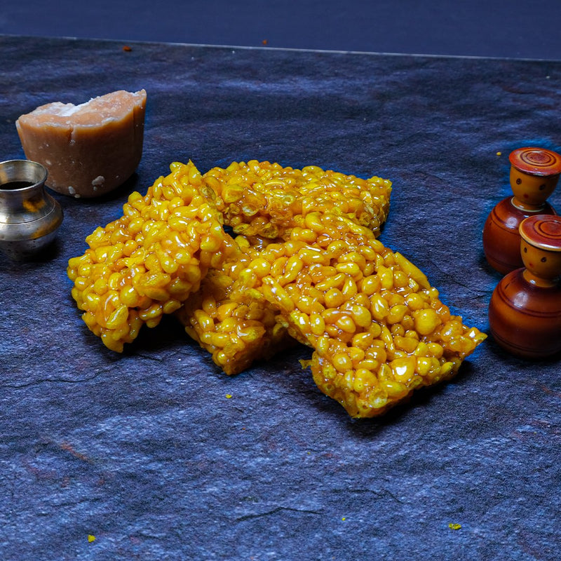 Yellow crispy treats on a dark blue surface with small decorative items.