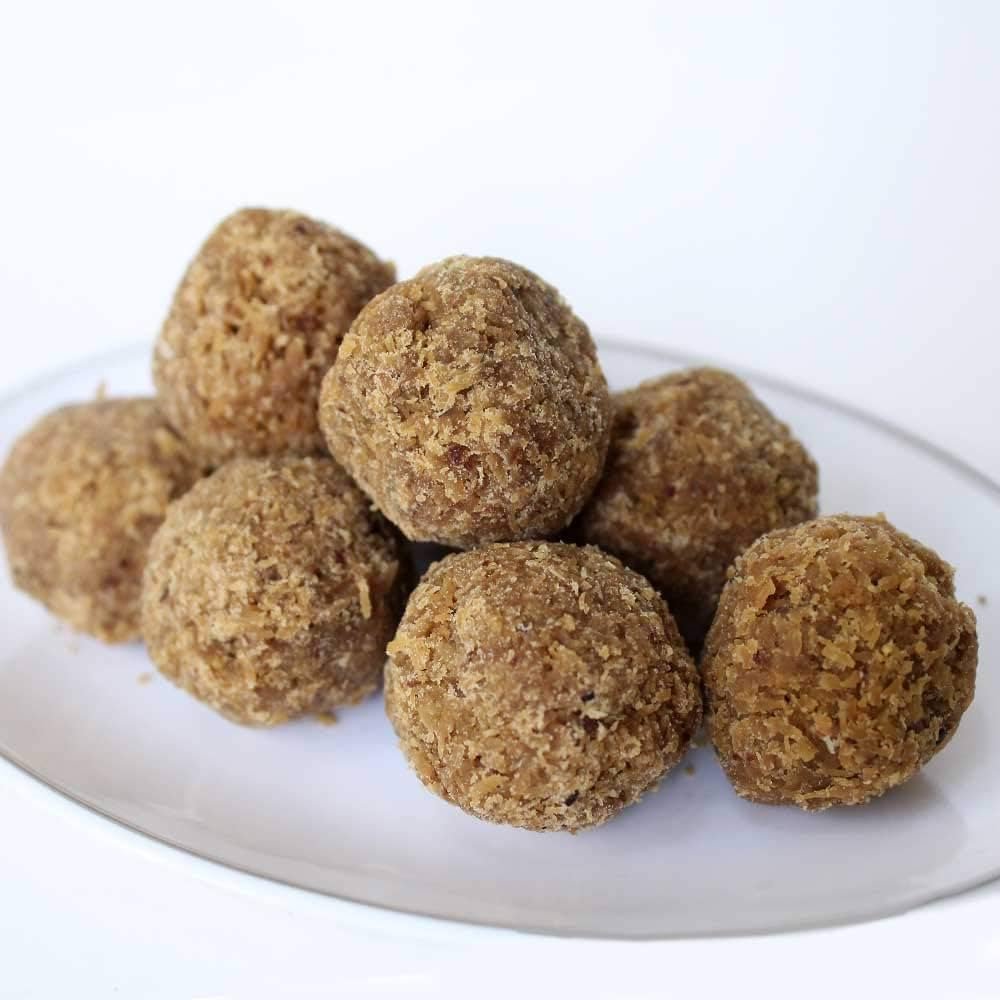 Brown spherical treats on a white plate with a white background