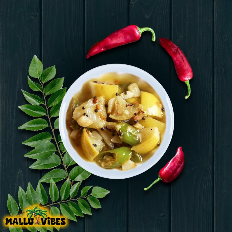 White bowl of vegetable stew with red and green peppers and curry leaves on a dark wooden background, featuring 'Mallu Vibes' logo.