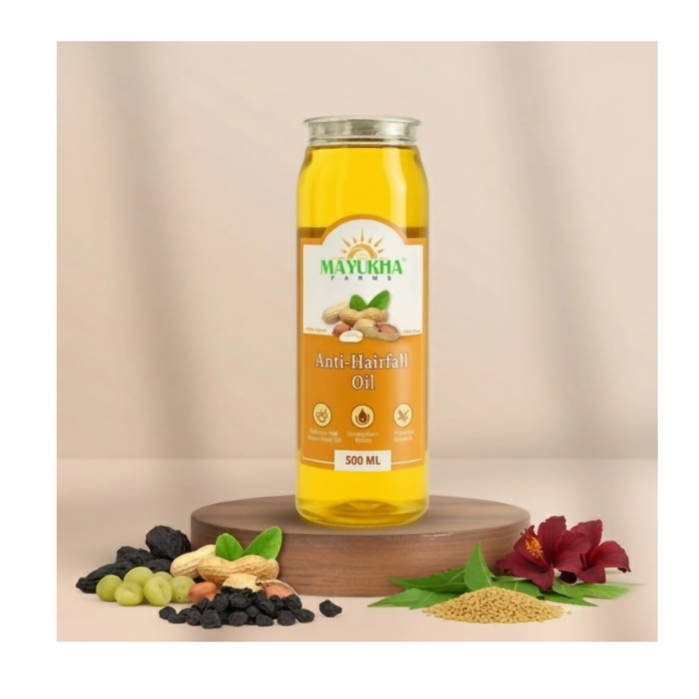 Mayukha Anti-Hairfall Oil bottle with ingredients on a beige background
