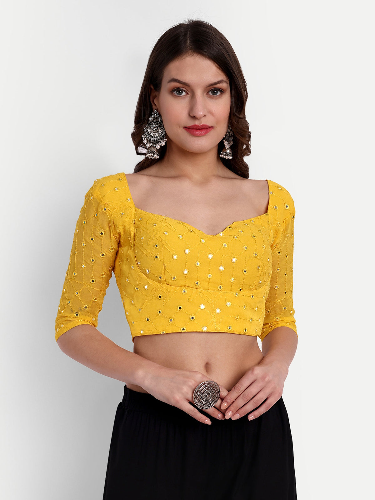 Woman wearing a yellow blouse with black pants on a white background