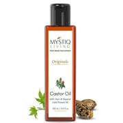 Mystiq Living Castor Oil bottle with leaves and seeds on a white background