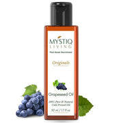 Bottle of Mystiq Living Grapeseed Oil with grapes and leaves on a white background