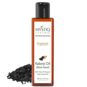 Bottle of Mystiq Living Kalonji Oil with black seeds on a white background