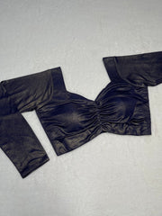 Black satin top with a bow detail on a light gray background