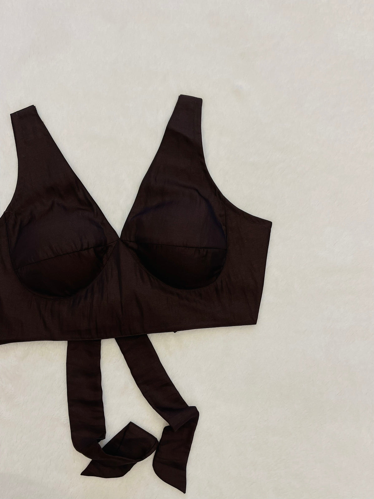 Brown bra and panties set on a light beige background
