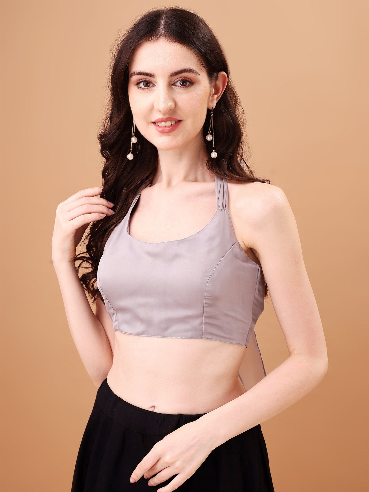 Woman wearing a gray top and black skirt against a beige background