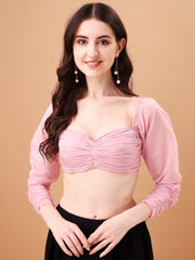 Woman wearing a pink top with long sleeves against a beige background
