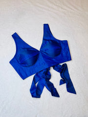 Blue bikini top with a bow on a light gray background