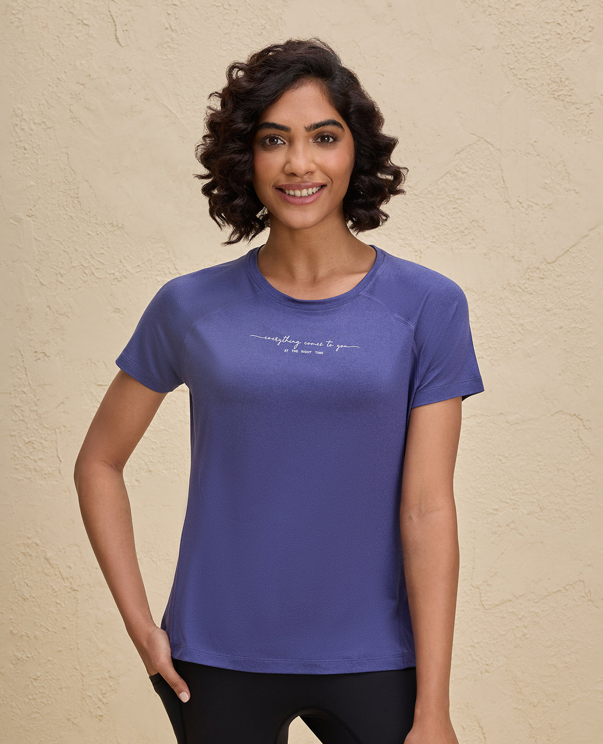 Woman wearing a blue t-shirt with text on a beige background