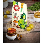 Amla pickle packaging with amla fruits on a wooden background