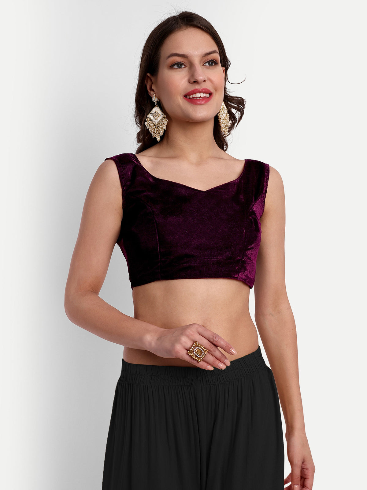 Woman wearing a dark purple top and black skirt on a white background