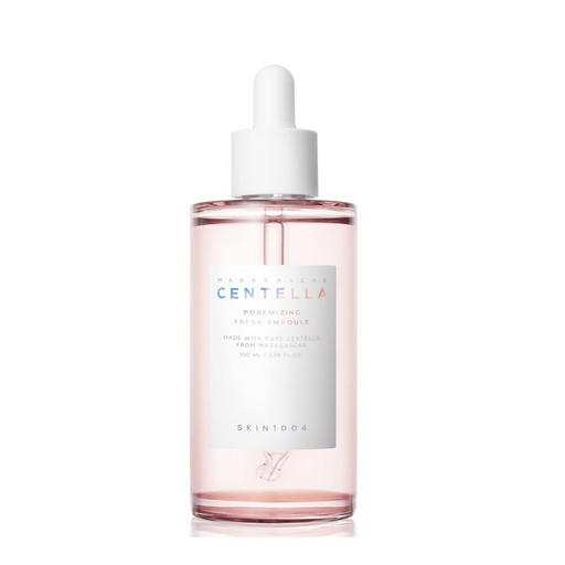 Skincare bottle with pink liquid and white cap on a white background