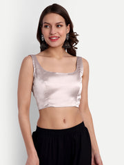 Woman wearing a light pink satin top and black pants on a white background