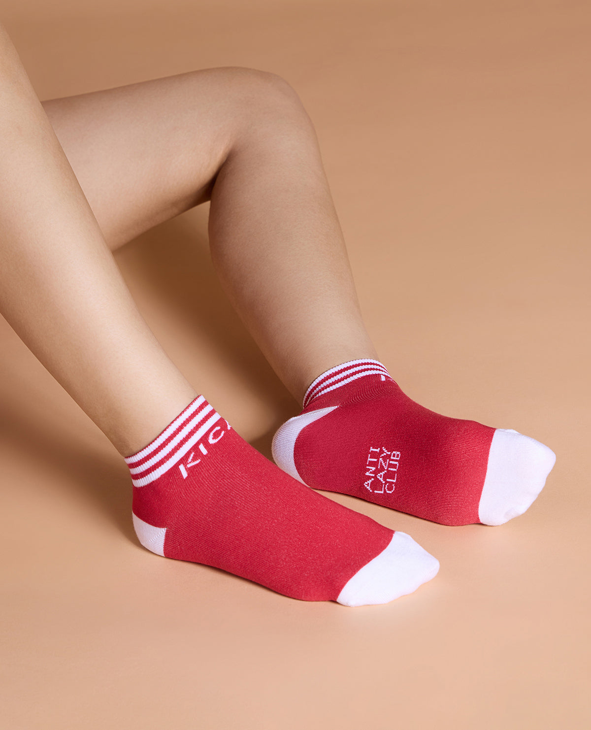 Red socks with white stripes and cuffs on a beige background