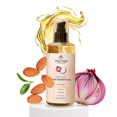Bottle of onion hair growth oil with ingredients on a white background