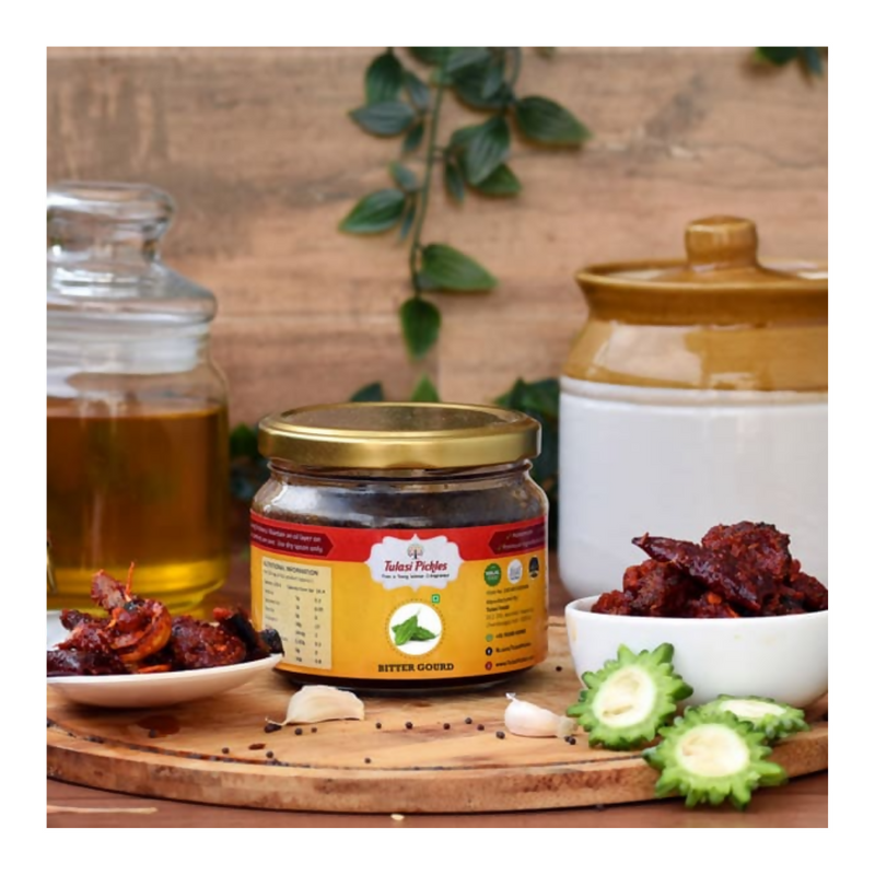 Jar of pickled bitter gourd with ingredients on a wooden board