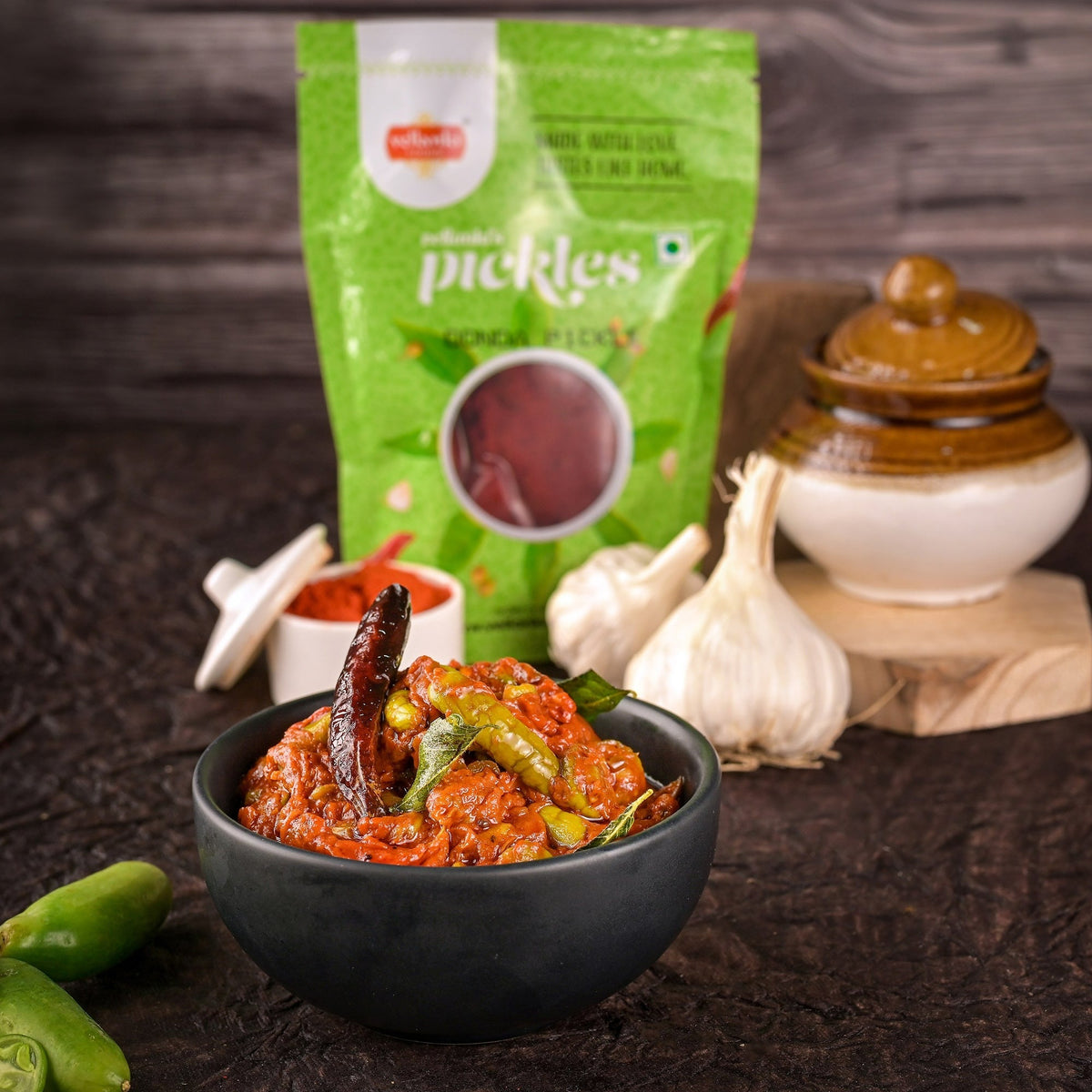 Bowl of pickles with a green packet labeled 'pickles' in the background.
