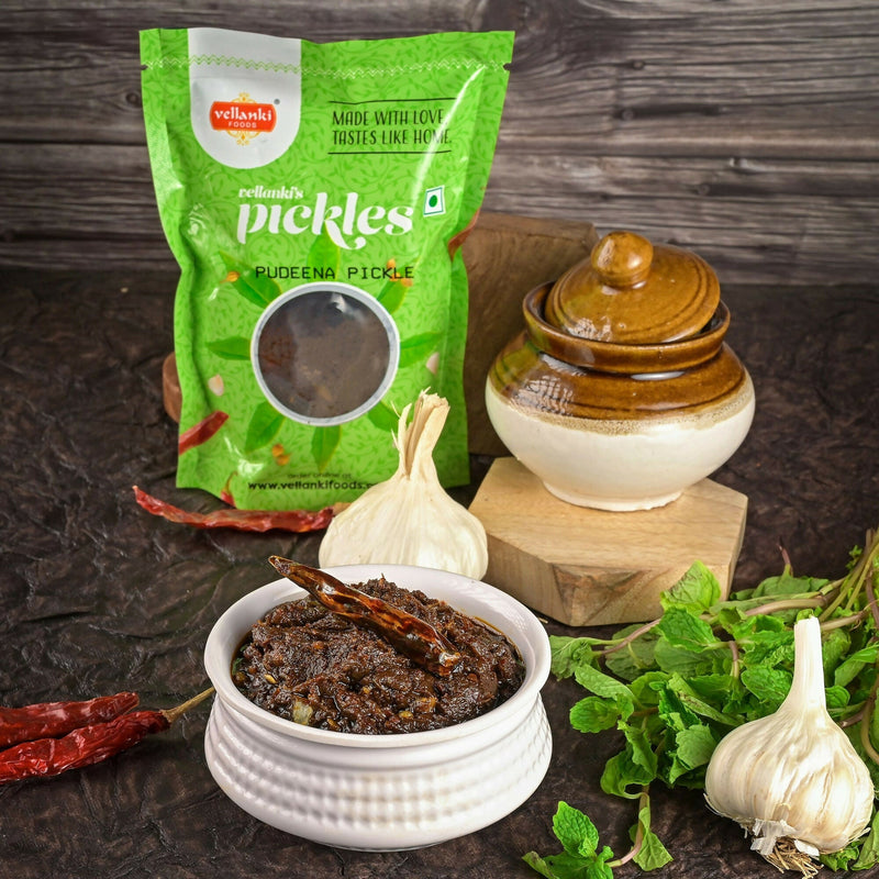 Vellanki pickle packaging with a bowl of pickle, garlic, and herbs on a wooden background